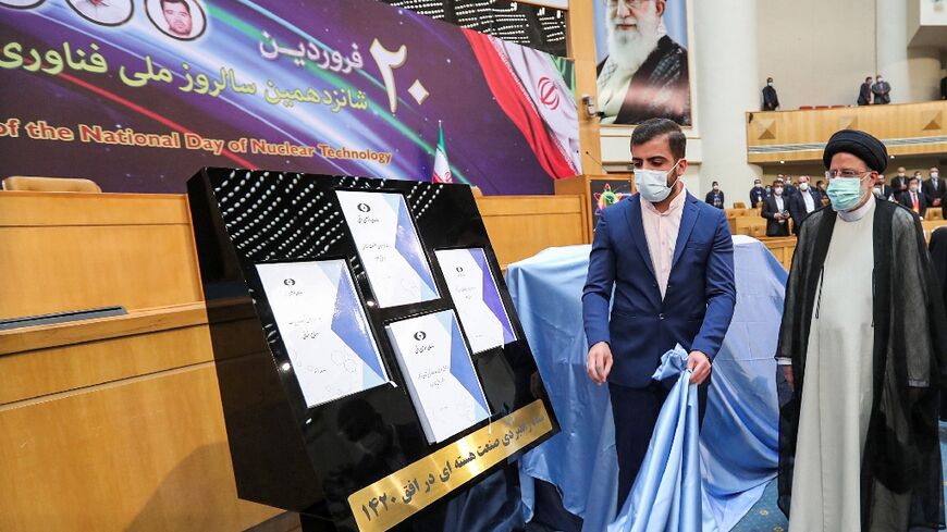 Iran's President Ebrahim Raisi (R) witnesses unveiling of the "Nuclear Industry Strategic Document" for the next two decades at an event during the 16th "National Day of Nuclear Technology" in Tehran on April 9, 2022