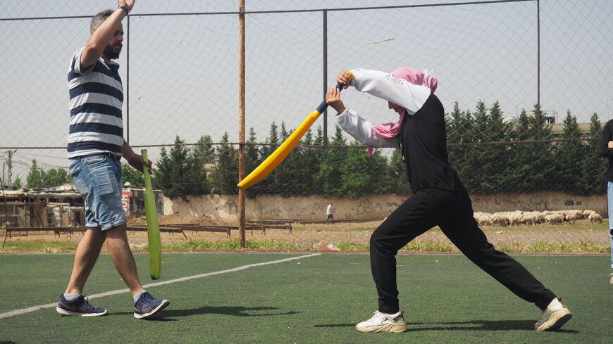 Mohammed Khier, head coach of Alsama cricket club, with cricketer Aya Fakhri Diab during practice in Al Marj camp.