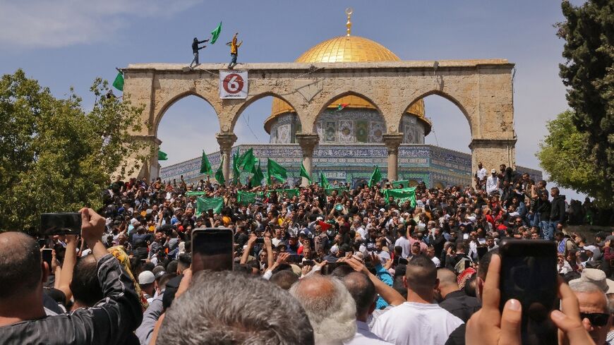 Palestinian gather to protest after Friday prayers, the third of the Muslim holy month of Ramadan, at Jerusalem's Al-Aqsa mosque compound, on April 22, 2022
