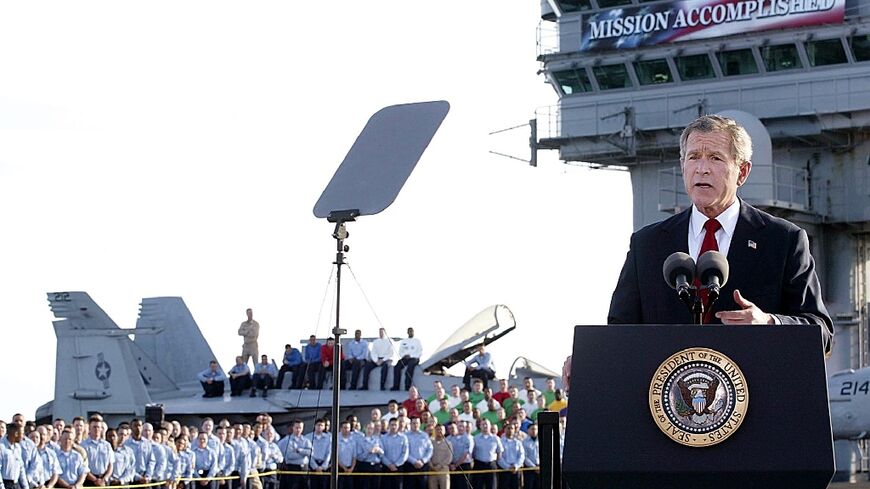 US President George W. Bush addresses his nation aboard the aircraft carrier USS Abraham Lincoln in the Gulf on May 1, 2003, in front of a banner reading "Mission Accomplished" --  a claim belied by years more of hard fighting in Iraq