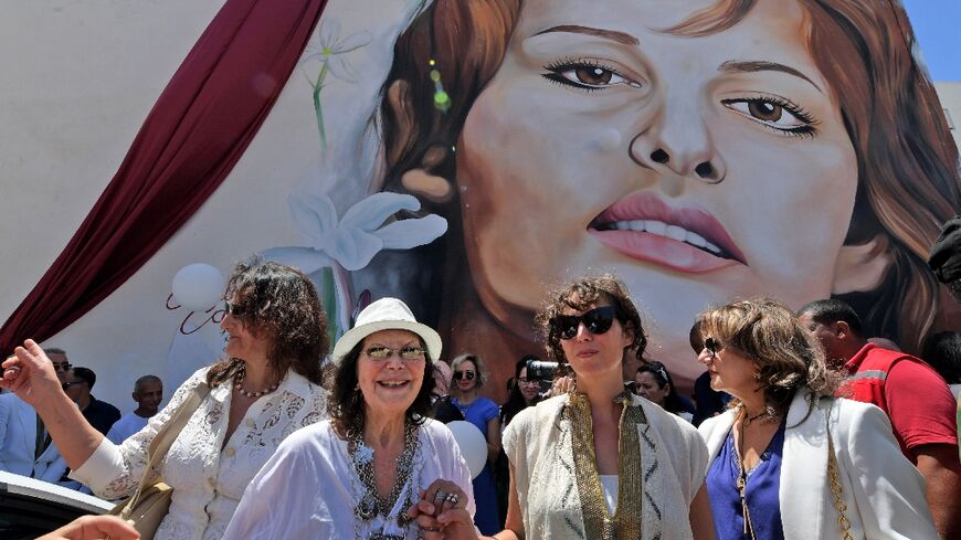 Italian-Tunisian actress Claudia Cardinale (2nd-L) poses in front of a mural of her during a street naming ceremony in her honour in Tunisia