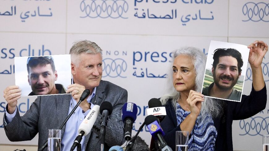 Marc (L) and Debra Tice, parents of US journalist Austin Tice, hold portraits of him during a press conference in 2017