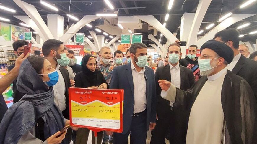 President Ebrahim Raisi visits a supermarket in Terhan as protests erupt across Iran against sharp rises in the cost of basic goods