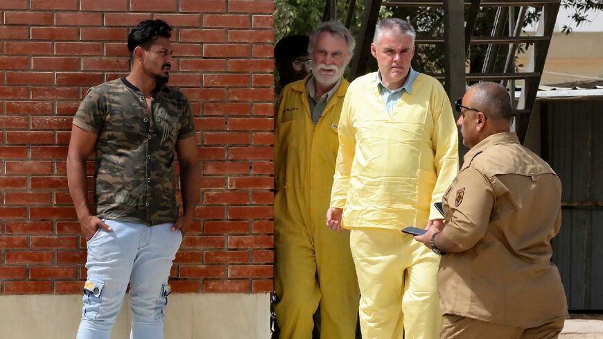 James Fitton, 66, a retired British geologist (L), and Volker Waldmann, 60, a Berlin psychologist, in the yellow uniform of detainees, arrive at a  courthouse in the Iraqi capital Baghdad
