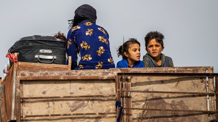 Syrian Kurdish and Arab families are pictured fleeing in the countryside of the town of Darbasiyah.