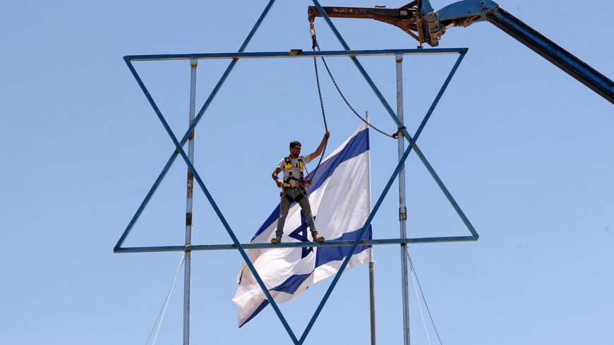 An Israeli settler adds the finishing touches to a large Star of David.