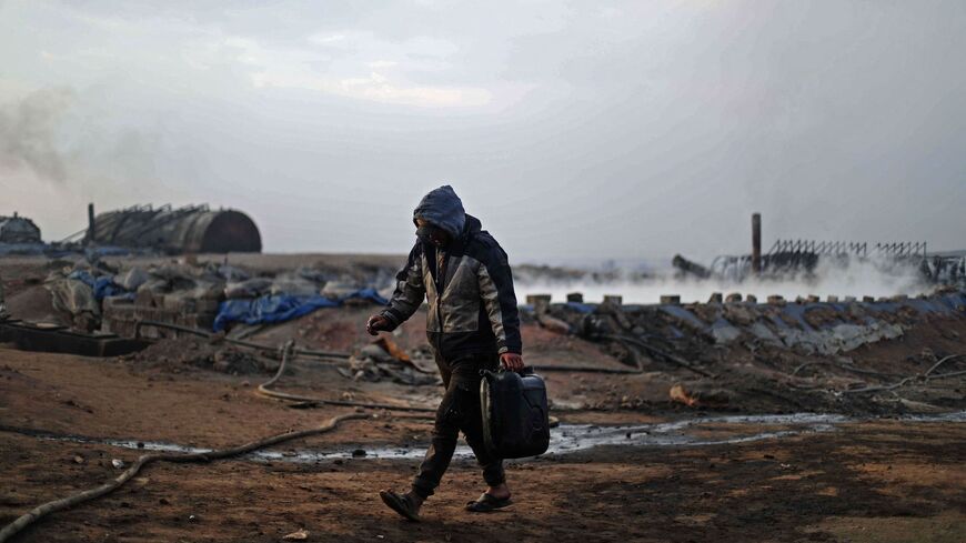 A Syrian worker is pictured at a makeshift refining installation in the Tarhin area near the Turkish-controlled city of al-Bab, in the north of the Aleppo province, on Nov. 19, 2021.
