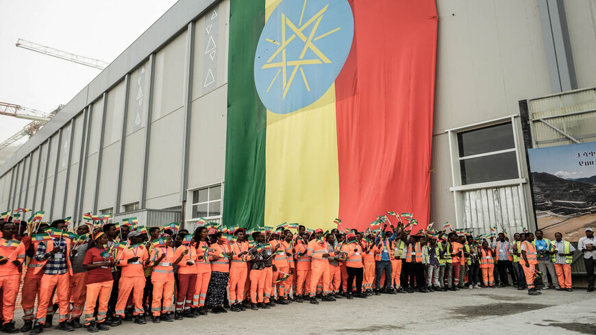 Workers celebrate waving Ethiopias flag during the first power generation ceremony at the site of the Grand Ethiopian Renaissance Dam, Guba, Ethiopia, Feb. 20, 2022.