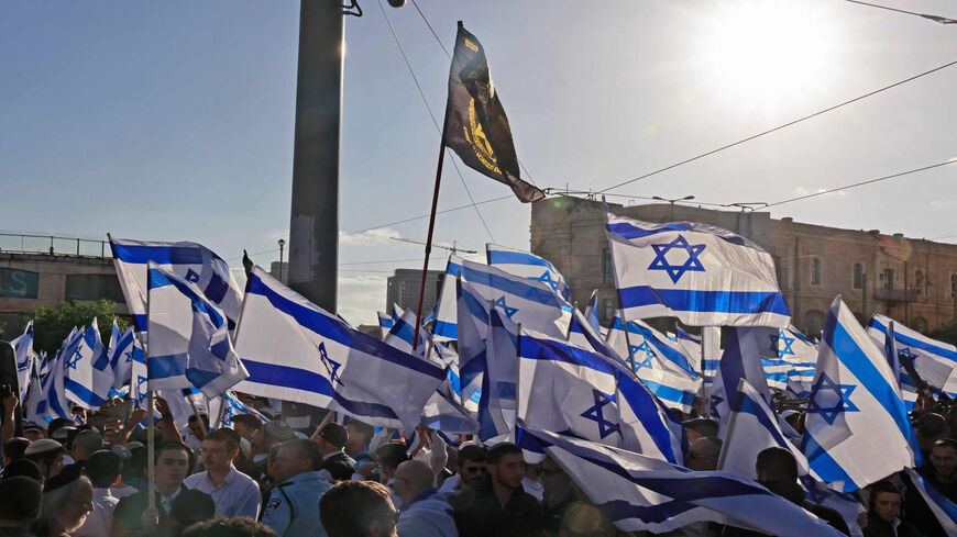 Israeli protesters wave national flags as they march toward Tzahal Square during the Flag March organized by nationalist parties, Jerusalem, April 20, 2022.