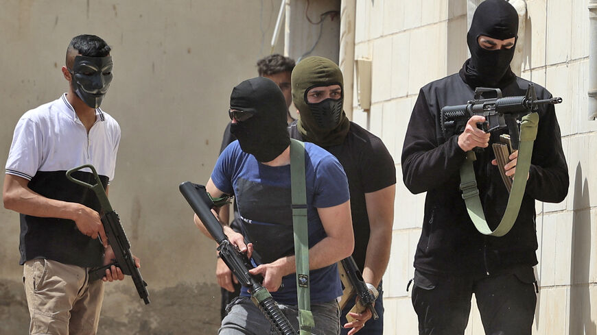 Masked Palestinian men hold automatic weapons.