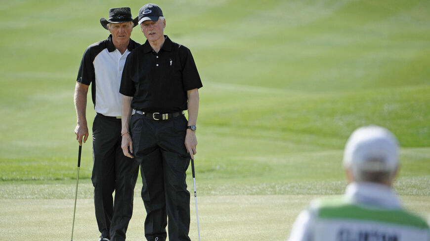 Former President Bill Clinton, right, and Greg Norman of Australia line up a putt.