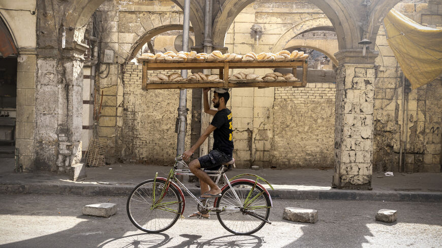Workers on bikes deliver Egyptian traditional Baladi bread.