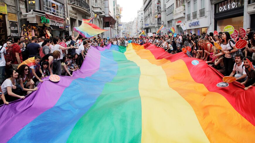 People hold a giant rainbow flag during a parade on Istiklal Street.