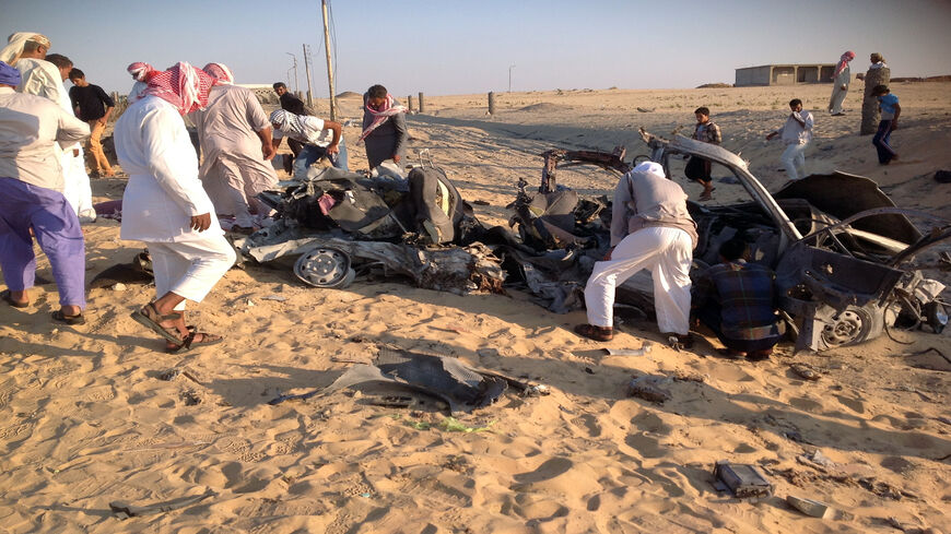 Egyptians gather near a car that exploded after a bomb went off before reaching the intended target, killing three passengers, el-Arish, Sinai Peninsula, July 24, 2013.