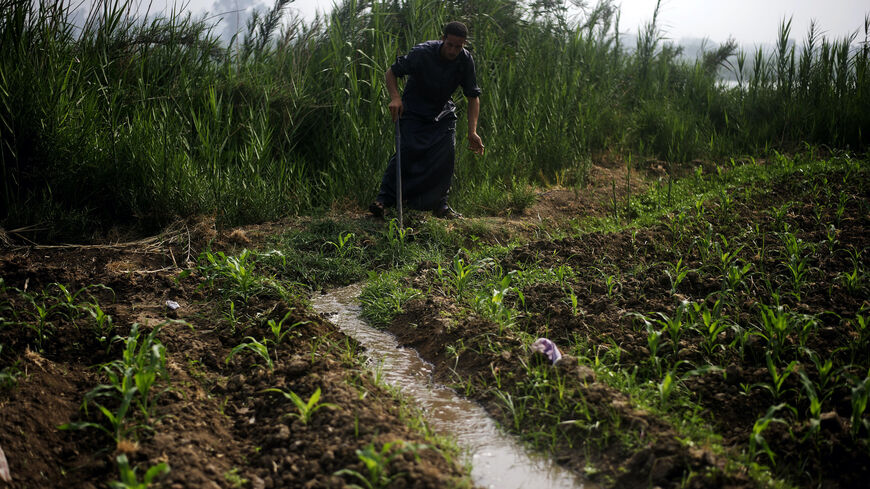 An Egyptian farmer opens up a water irrigation system as he tends to his fields on the banks of the Rasheed river, an offshoot of the Nile, in Cairo's northern Giza province, some 40 kilometres north of the capital, on June 22, 2013.