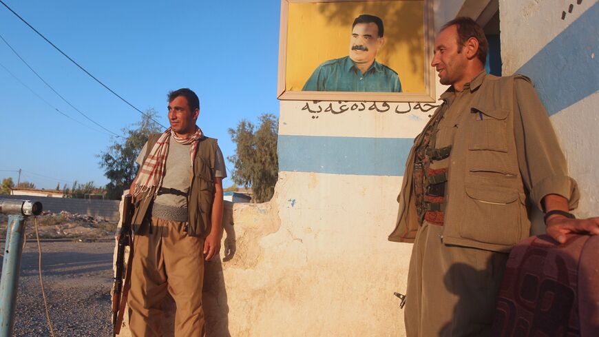 PKK fighters guard a post bearing an image of jailed PKK leader Abdullah Ocalan.