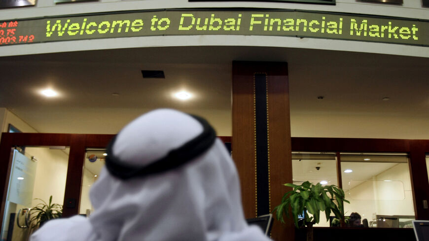 n Emirati man follows the market's movement at the Dubai Financial Market.