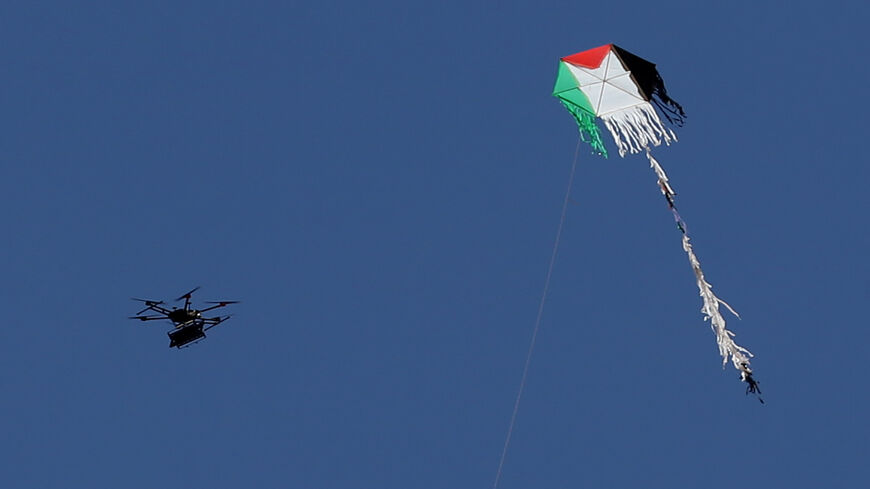 An Israeli army drone flies near a Palestinian kite along the border between Israel and the Gaza Strip, east of Gaza City, May 14, 2018.