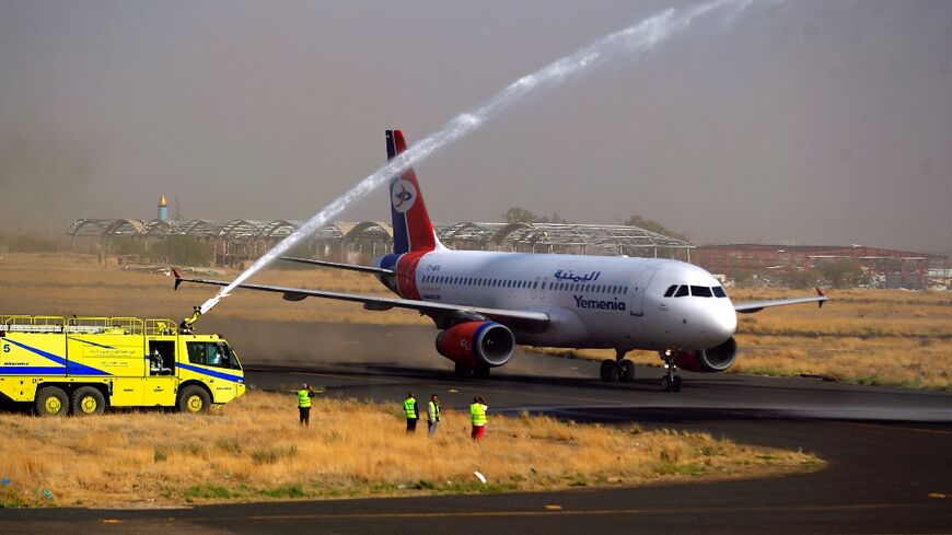 A firefighter truck celebrates with a water jet the first Yemen Airways flight in six years to leave from Sanaa airport