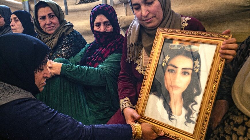 Hiam Saadoun holds a photograph of her daughter Inas Abdel Salam, 23, who is listed as missing along with her friend Jenda Saeed, 27, after they tried to reach Europe