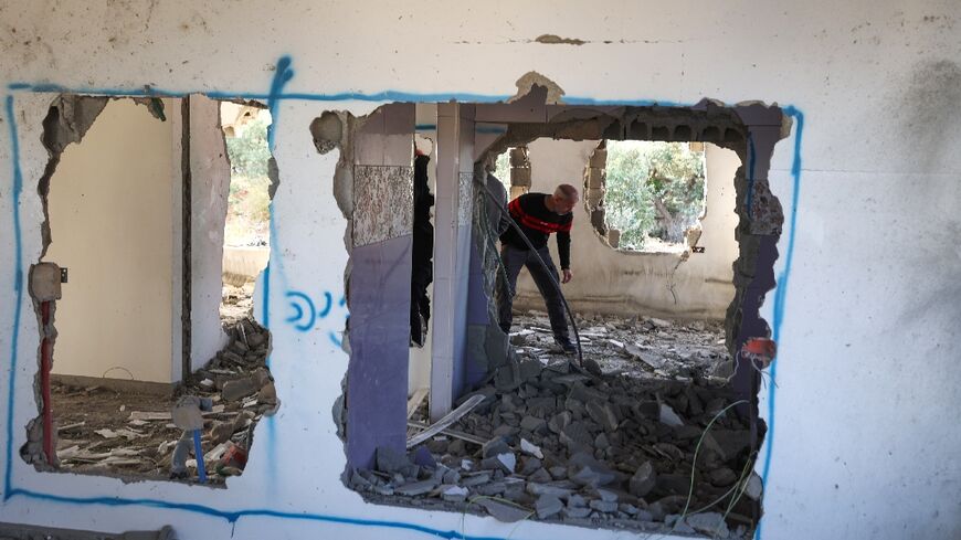 A Palestinian man inspects the home of Omar Jaradat demolished by Israeli security forces after they accused him of killing a Jewish settler