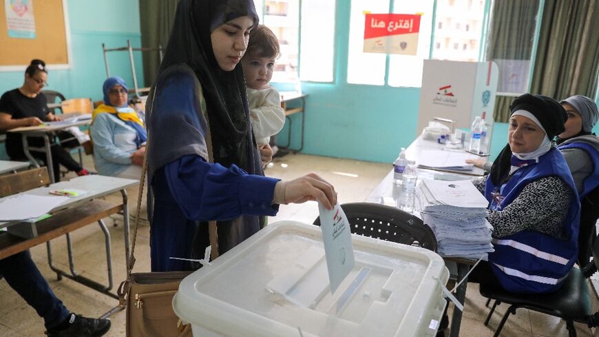 A voter casts her ballot for the parliamentary election at a polling station in the Lebanese capital Beirut, on May 15, 2022