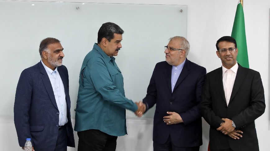 Handout picture released by the Venezuelan Presidency showing President Nicolas Maduro (2-L) shaking hands with Iran's Oil Minister Javad Owji (2-R) during his visit to Miraflores Presidential Palace for a private meeting in Caracas on May 2, 2022