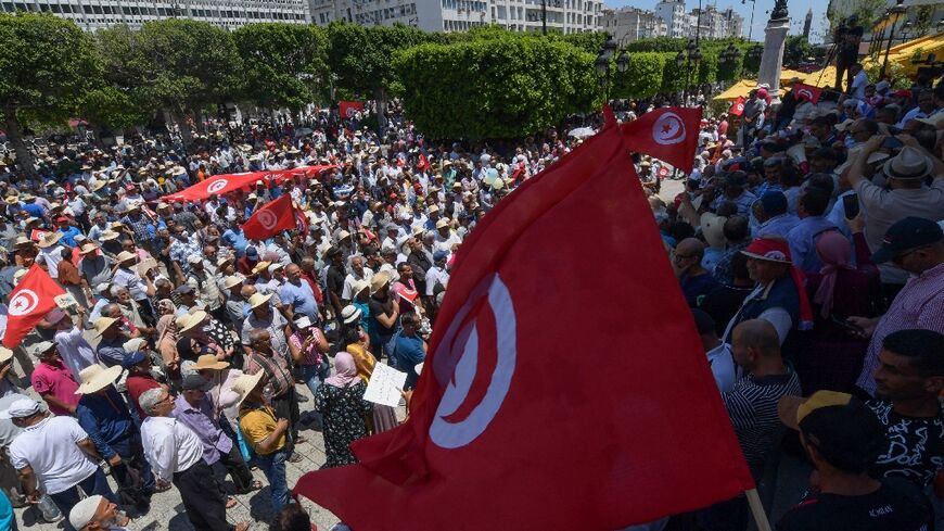 Tunisian protesters wave national flags during a demonstration in the capital Tunis against President Kais Saied and an upcoming July 25 constitutional referendum