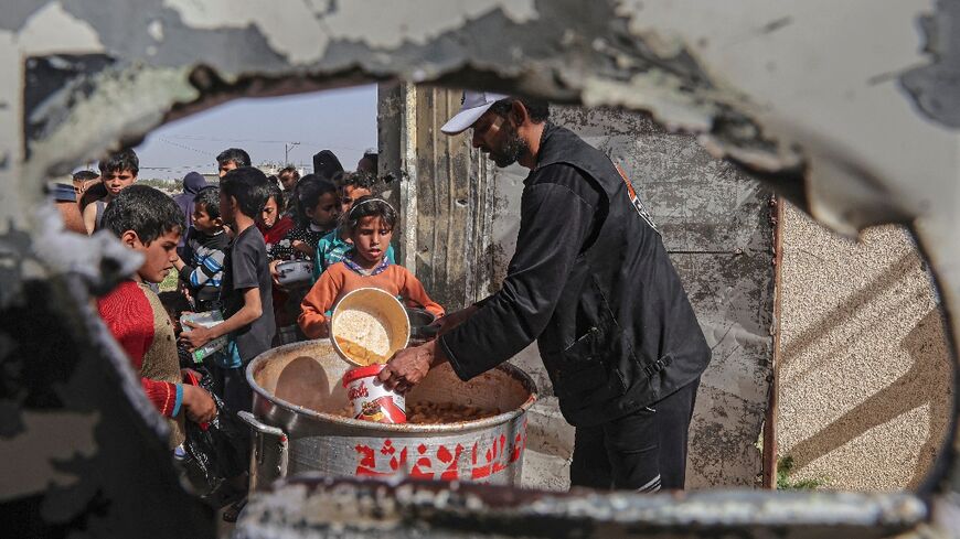 Palestinian children in the Israeli-blockaded Gaza Strip queue for free meals to break the daytime fast during the Muslim holy month of Ramadan