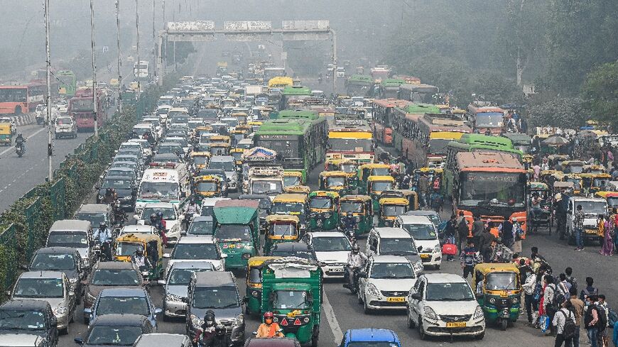 Commuters make their way along a busy road under heavy smoggy conditions in New Delhi 