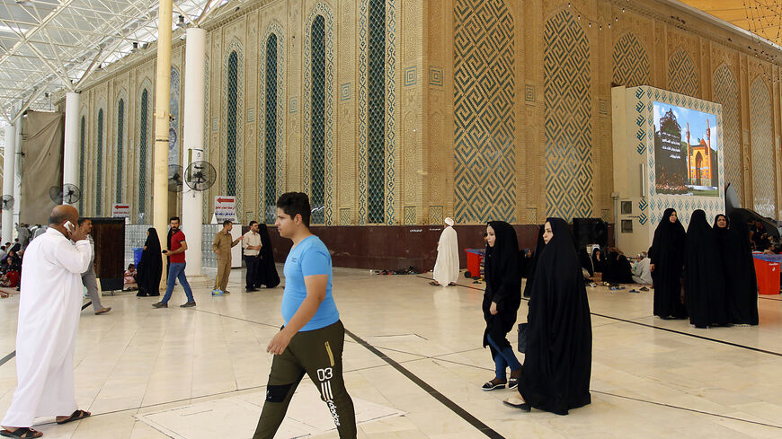 Tourists stroll at a holy site in the Iraqi city of Najaf on Aug. 14, 2018.
