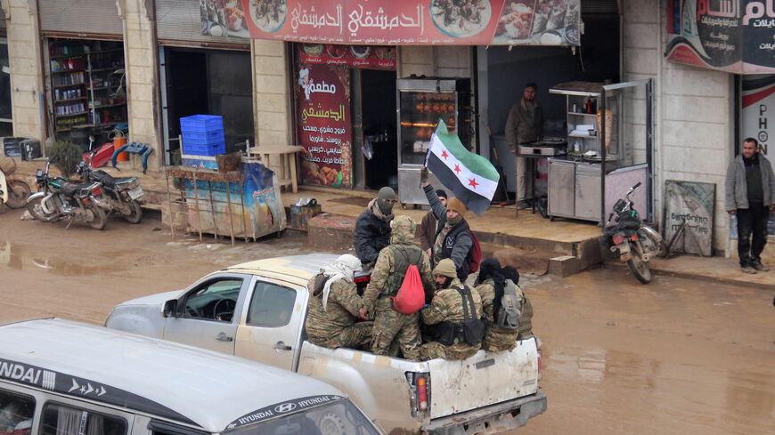 Members of the Free Syrian Army wave the flag of the Syrian opposition as they travel in a truck through the town of Hazano, in Idlib's northern countryside, as reinforcements are deployed from Aleppo's northern countryside to Idlib's countryside to counter an ongoing pro-regime offensive, Syria, Feb. 5, 2020.