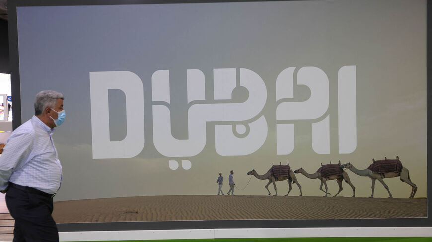 A visitor walks past a Dubai billboard at the Arabian Travel market exibition in the Gulf emirate, May 17, 2021.
