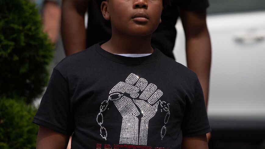 A boy listens to Live Go-Go music playing at Black Lives Matter Plaza in Washington, DC, on June 19, 2021.