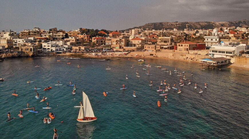 An aerial view taken on Oct. 2, 2021, shows people swimming and paddling off the coast of the northern Lebanese city of Batroun.
