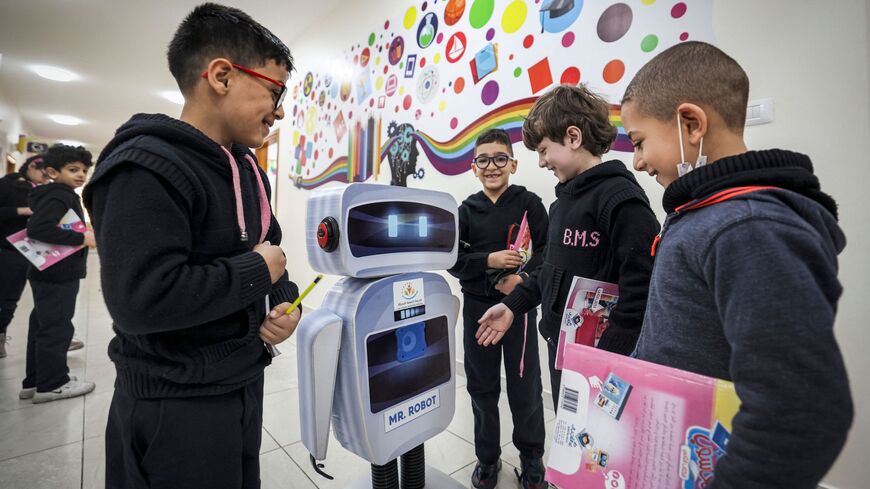 Palestinian students interact with a locally made educational robot.
