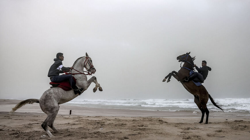 Youths rear their horses as they ride during stormy weather along a beach by the Mediterranean Sea in Gaza City, Gaza Strip, Dec. 8, 2021.