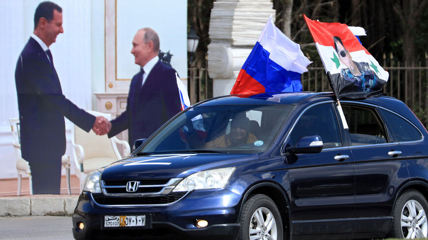 Syrians wave flag of Russia and a portrait of President Bashar al-Assad.