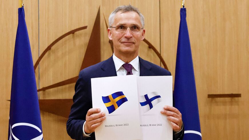 NATO Secretary-General Jens Stoltenberg poses with application documents.