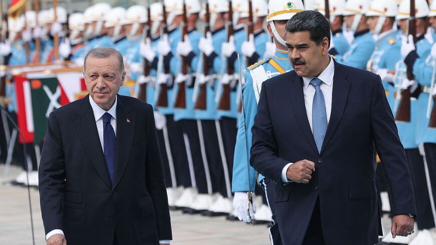 Turkish President Recep Tayyip Erdogan (L) walks with his Venezuelan counterpart, Nicolas Maduro.