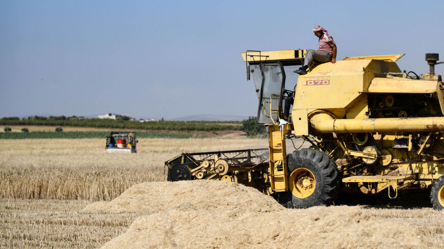 A farmer harvests wheat with a combine machine, in the countryside of the northwestern city of Afrin in the rebel-held part of Aleppo province, Syria, June 8, 2022.