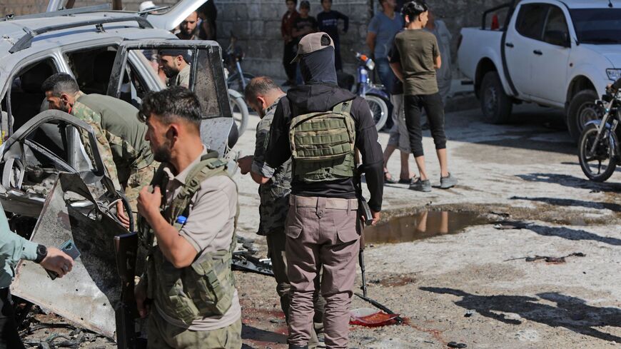 Local security forces inspect the scene of a car bomb explosion in the Turkish-held Syrian city of al-Bab.