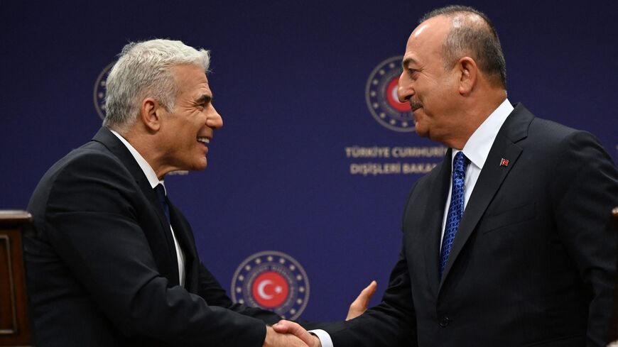 Turkish Foreign Minister Mevlut Cavusoglu (R) and Israeli Foreign Minister Yair Lapid (L).