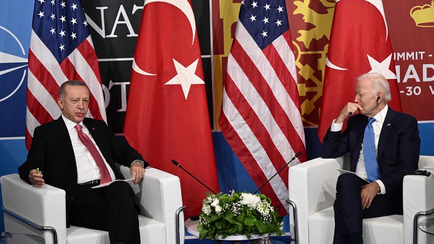 US President Joe Biden (R) listens as Turkey's President Recep Tayyip Erdogan.