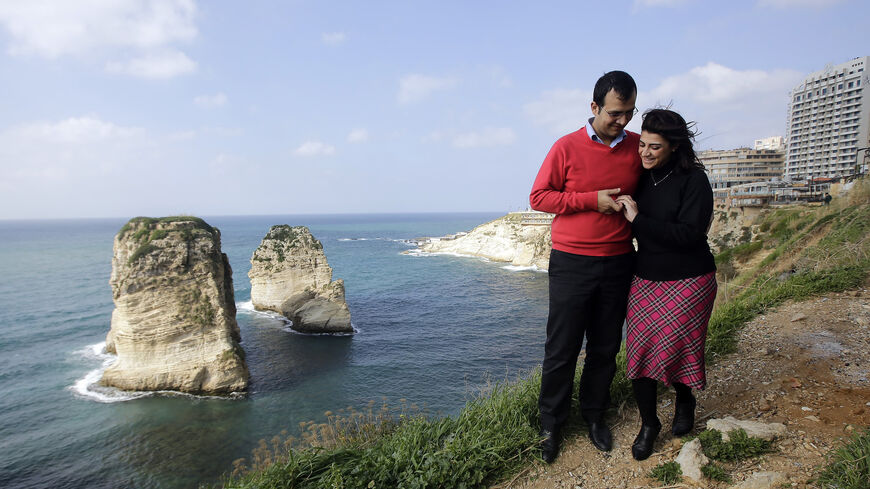 Kholoud Sukkarieh (R) and Nidal Darwish, who got married in defiance of the ban on civil unions, walk past Pigeon Rock, Beirut, Lebanon, Jan. 25, 2013.