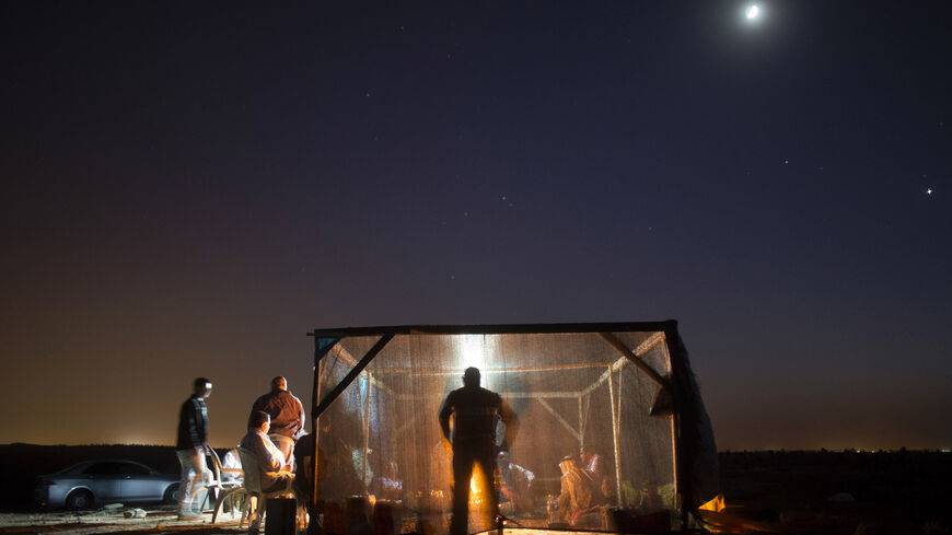 Bedouin men eat their dinner in a tent on Oct. 9, 2013, in the Bedouin village of Al-Arakib, Israel.