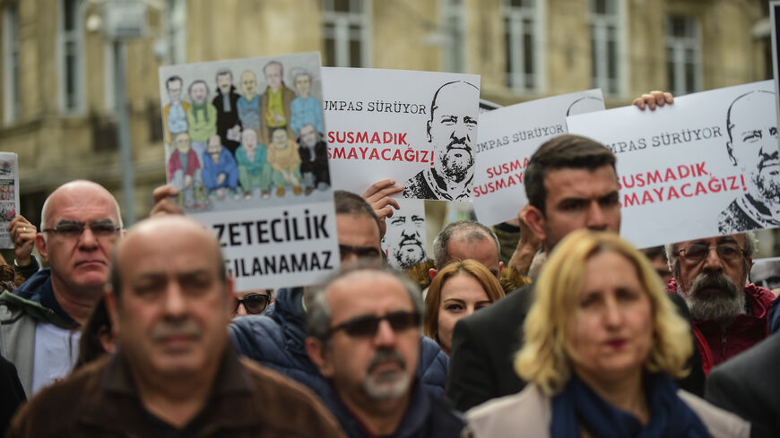 People and journalists hold banners reading "Freedom for jailed journalists - we will not be silenced" on April 9, 2017 during a demonstration for the freedom of the press in Istanbul. 