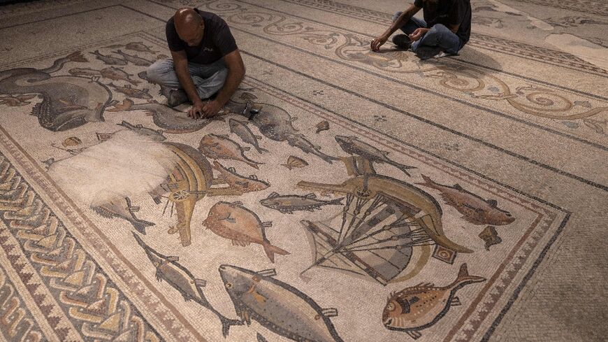 Israel Antiquities Authority workers attend to on the 1,700-year-old Lod mosaic