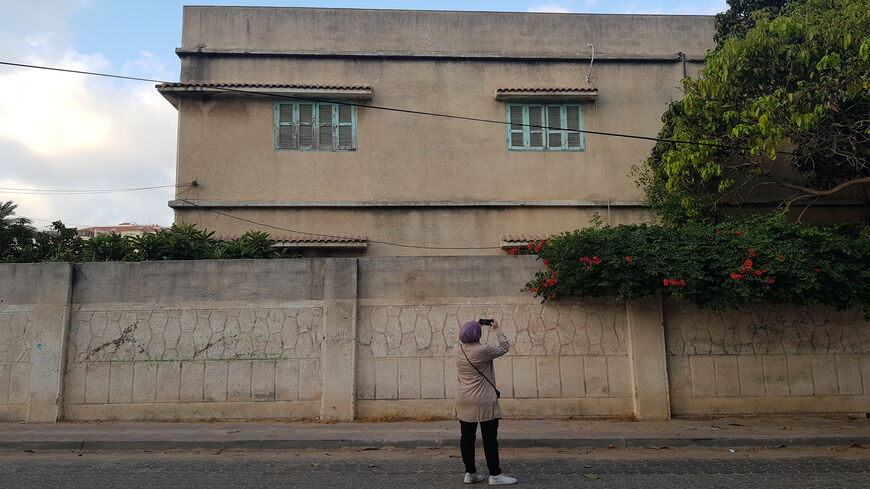 Haya Barzaq takes photographs of a building in Gaza City to track the evolution of architecture in Gaza City, Gaza Strip, June 2022.