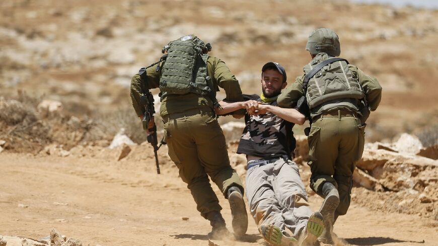 Israeli forces remove a demonstrator during a protest by Palestinians and international activists in the Masafer Yatta area of the Israeli-occupied West Bank on July 1, 2022